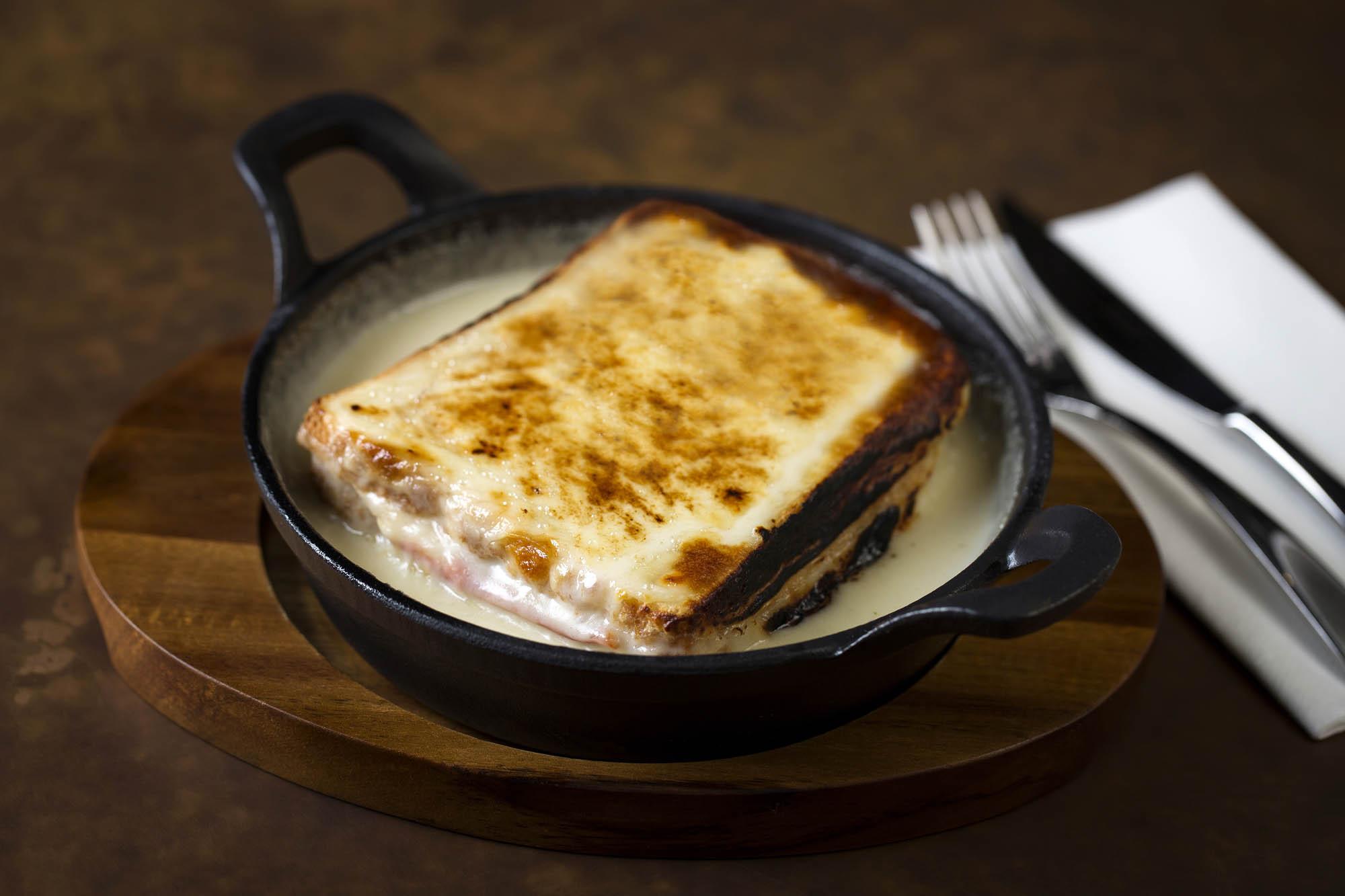 A golden croque monsieur in a cast-iron dish