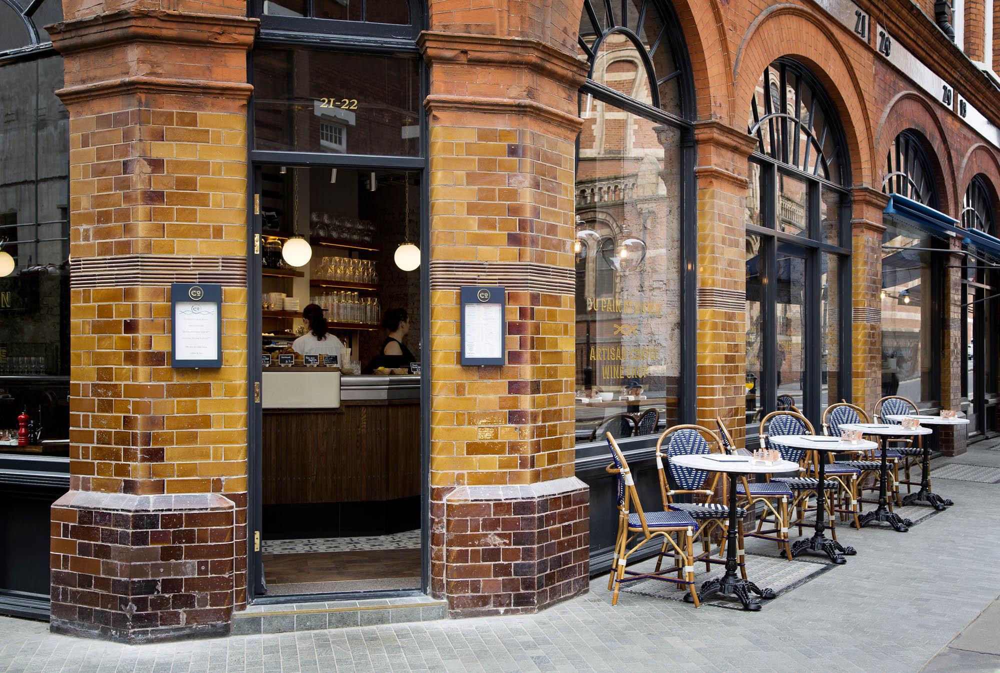 The corner of Comptoir on Weighhouse Street, with arched windows and pavement tables