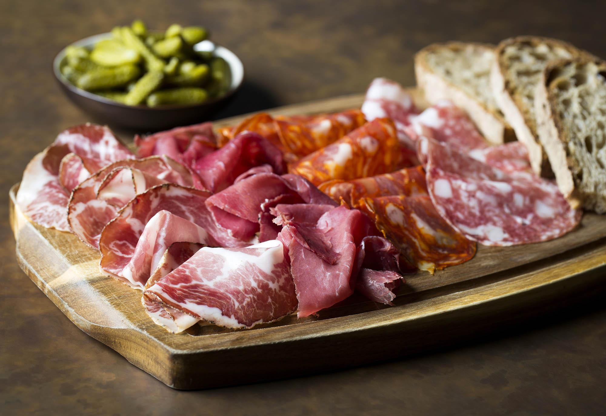 A board of cured meats with gherkins and sourdough