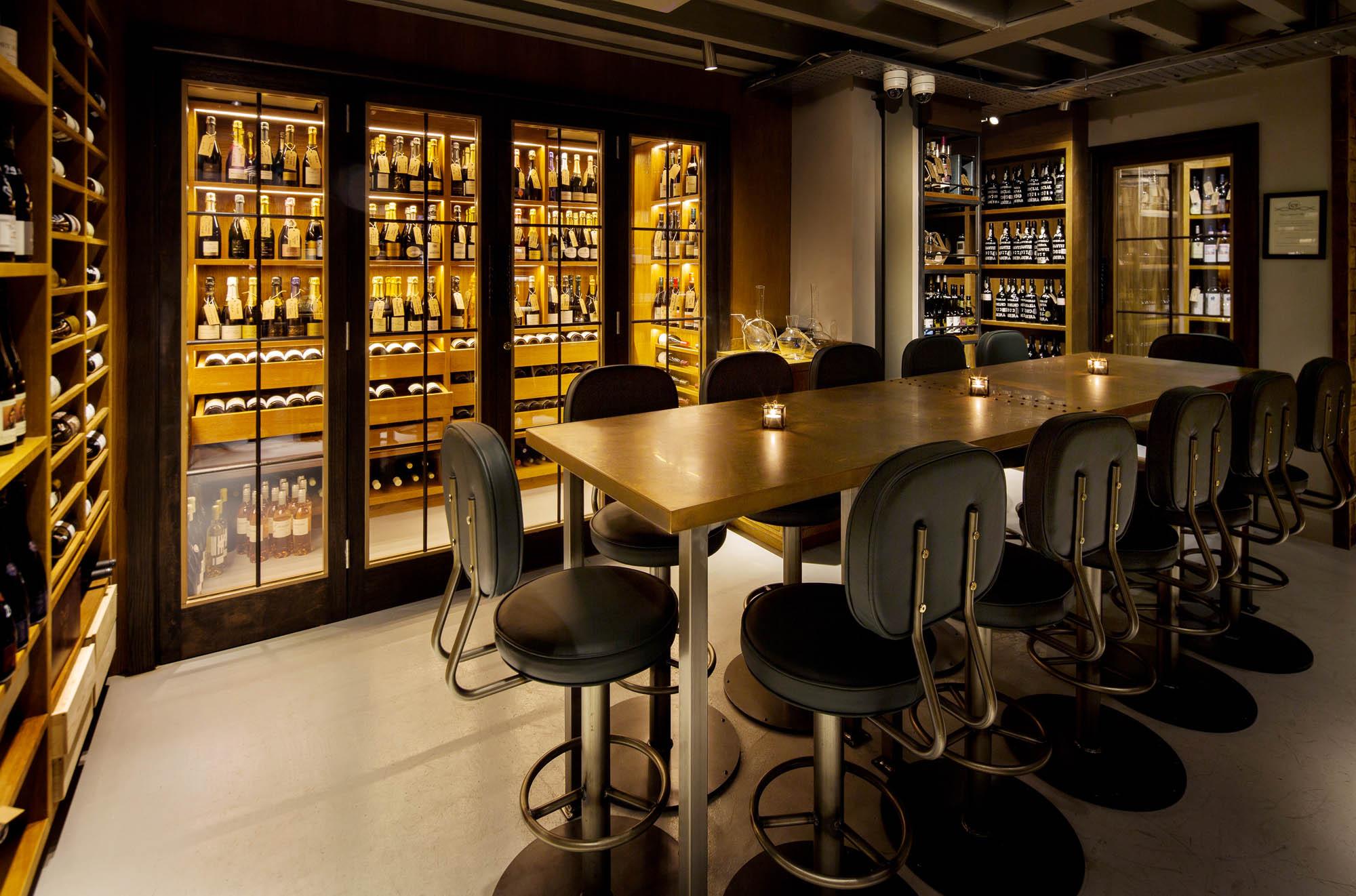 The wine room at Comptoir: backlit cabinets of bottles and a long communal table